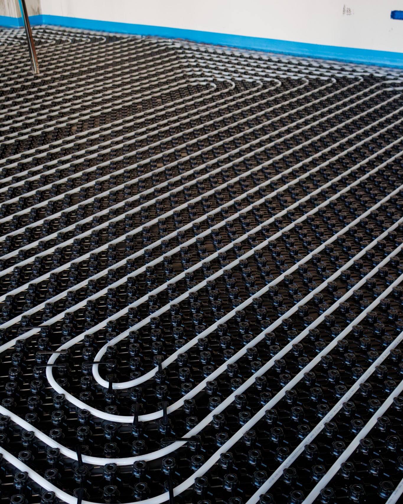 Impianto di riscaldamento a pavimento completato — serpentine PEX perfettamente allineate su pannello bugnato